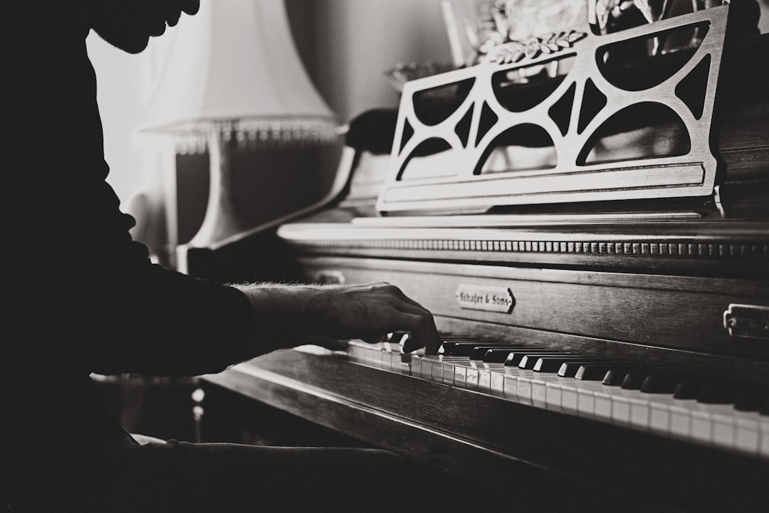 Vintage piano player by Playlist Names greyscale photo of man playing spinet piano close-up photo