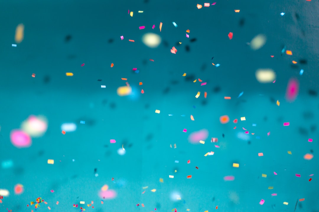 Colorful confetti falling down with a teal background by Playlist Names selective focus photography of multicolored confetti lot